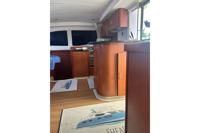 Shearwater Yacht Photos Pics Interior of 2011 Leopard 47 Powercat with wooden cabinetry and nautical-themed decor.