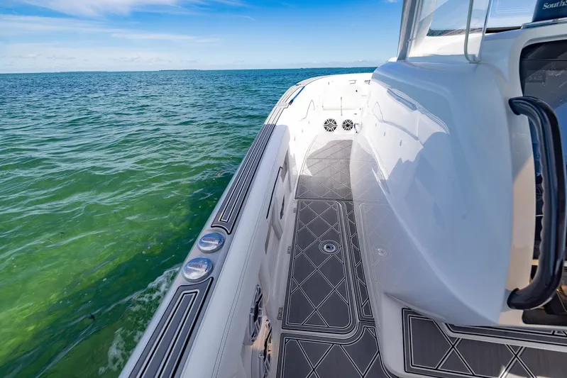  Yacht Photos Pics 2024 Deep Impact 399 Sport boat on clear ocean water, showcasing sleek deck design.