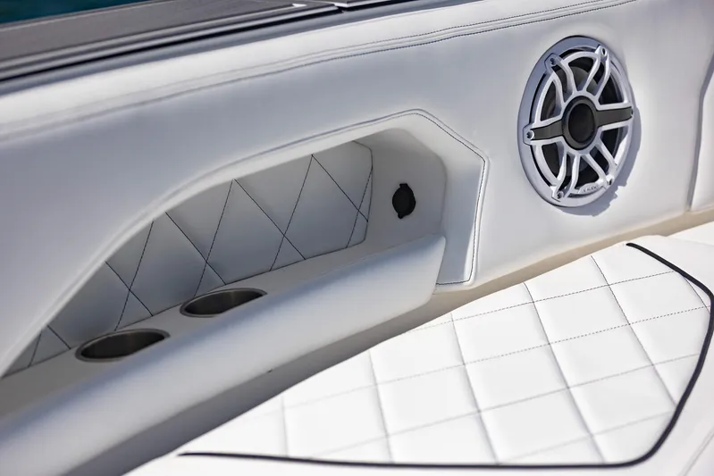  Yacht Photos Pics 2024 Deep Impact 399 Sport interior with white quilted upholstery and speaker detail.