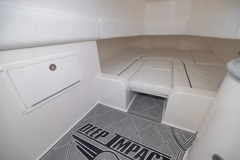  Yacht Photos Pics 2024 Deep Impact 399 Sport cabin interior with cushioned seating and branded flooring.