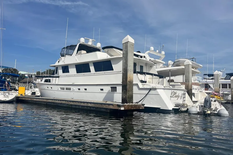 Lady T Yacht Photos Pics 1986 Hatteras 70 Cockpit Motor Yacht docked at marina under clear blue sky.