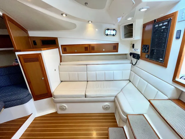 Wanda Lee Yacht Photos Pics Interior of a 1999 Cabo 31 Express boat with white seating and wooden accents.