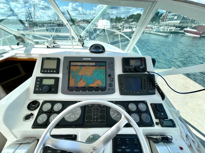 Wanda Lee Yacht Photos Pics Helm of 1999 Cabo 31 Express boat with navigation equipment and scenic marina view.