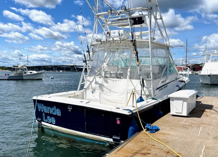 Wanda Lee Yacht Photos Pics 1999 Cabo 31 Express boat docked under a partly cloudy sky.