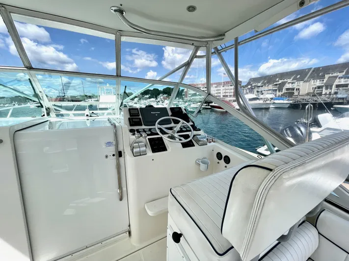 Wanda Lee Yacht Photos Pics 1999 Cabo 31 Express boat helm with marina view, featuring steering wheel and controls.