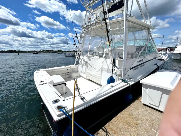 Wanda Lee Yacht Photos Pics 1999 Cabo 31 Express boat docked under a partly cloudy sky.