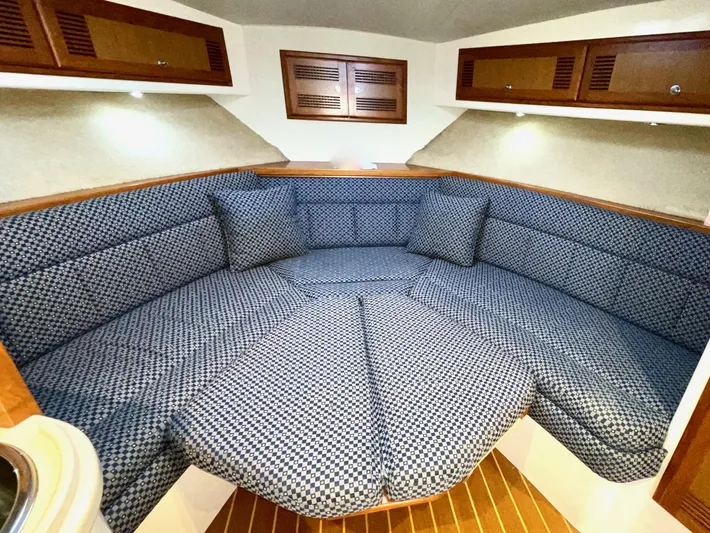Wanda Lee Yacht Photos Pics 1999 Cabo 31 Express cabin interior with blue patterned seating and wooden accents.