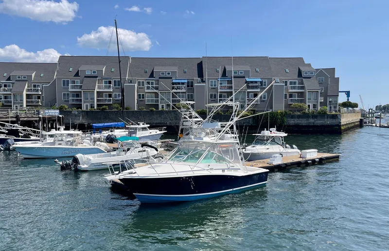 Wanda Lee Yacht Photos Pics 1999 Cabo 31 Express boat docked in marina with waterfront buildings in background.