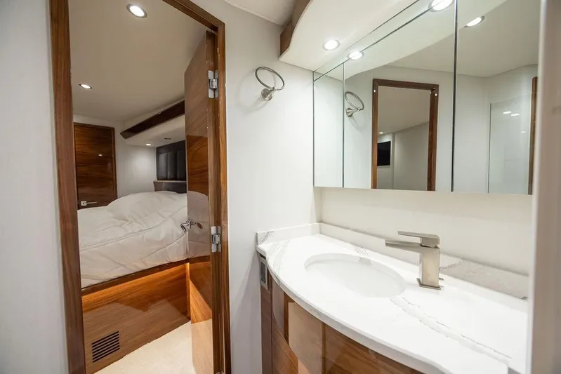 Seven Seas Yacht Photos Pics Luxurious interior of 2024 Viking 58 Convertible yacht, featuring elegant bathroom and cozy bedroom.