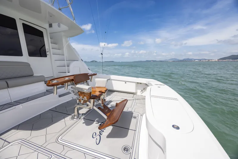 Seven Seas Yacht Photos Pics 2024 Viking 58 Convertible yacht deck with fishing chair, ocean view, and clear sky.