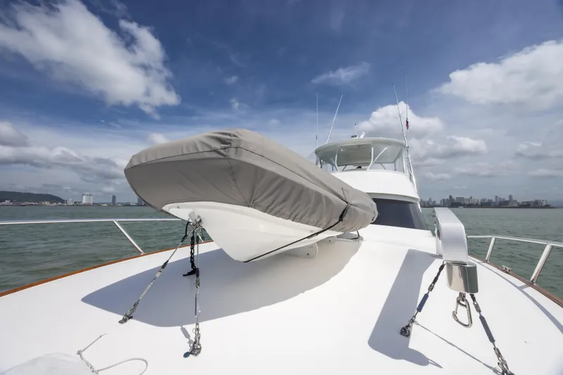 Seven Seas Yacht Photos Pics 2024 Viking 58 Convertible yacht with covered dinghy on deck, ocean and city skyline.