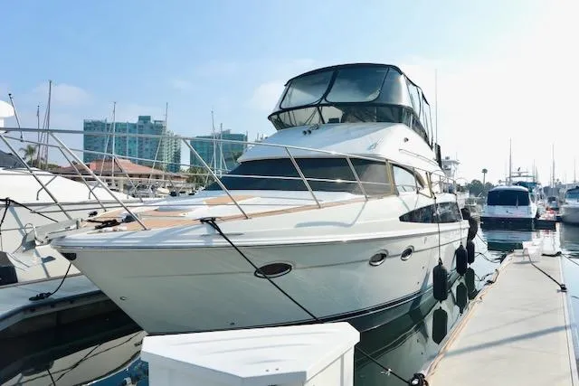 Four Us Yacht Photos Pics 2006 Carver 42 Super Sport yacht docked at marina under clear sky.