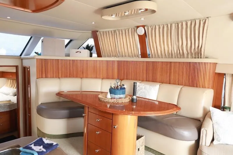 Four Us Yacht Photos Pics Luxurious interior of 2006 Carver 42 Super Sport yacht with elegant seating and wooden accents.