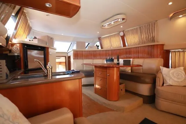 Four Us Yacht Photos Pics Luxurious interior of 2006 Carver 42 Super Sport yacht with elegant seating and kitchenette.