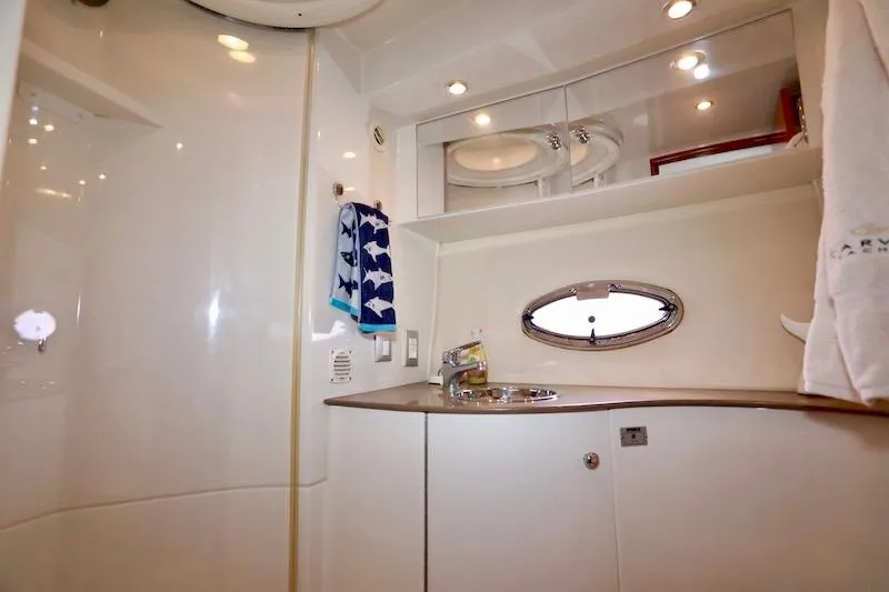 Four Us Yacht Photos Pics 2006 Carver 42 Super Sport yacht bathroom with sink, mirror, and porthole window.