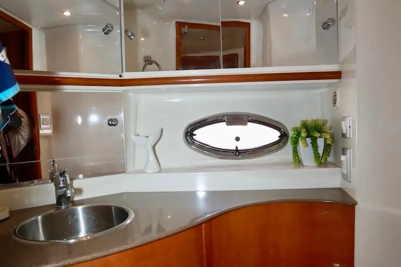 Four Us Yacht Photos Pics 2006 Carver 42 Super Sport yacht bathroom with sink, mirror, and porthole window.