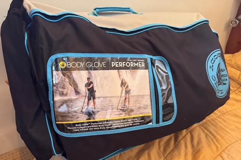 Four Us Yacht Photos Pics Bag containing Body Glove Performer inflatable paddle board, featuring user guide image.