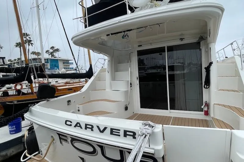 Four Us Yacht Photos Pics 2006 Carver 42 Super Sport yacht docked, featuring spacious deck and sliding glass doors.