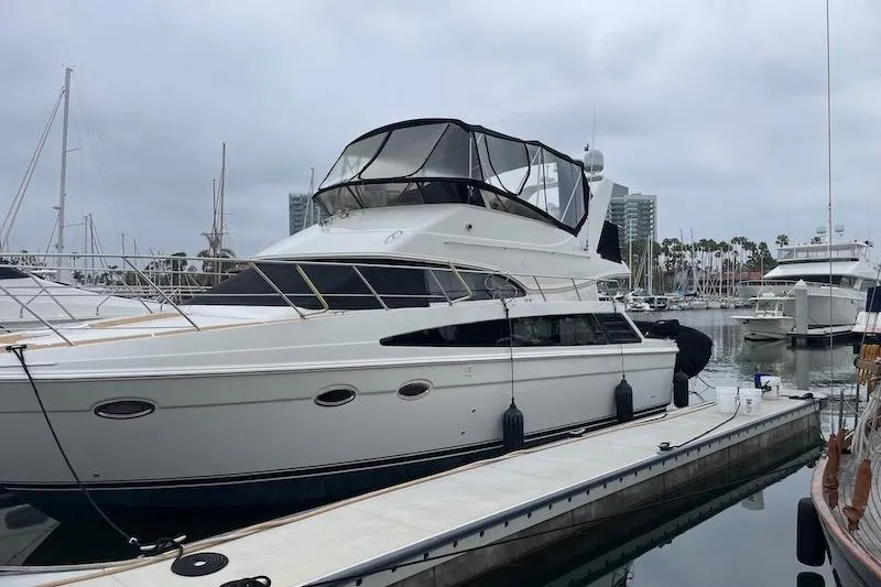 Four Us Yacht Photos Pics 2006 Carver 42 Super Sport yacht docked at a marina under cloudy skies.