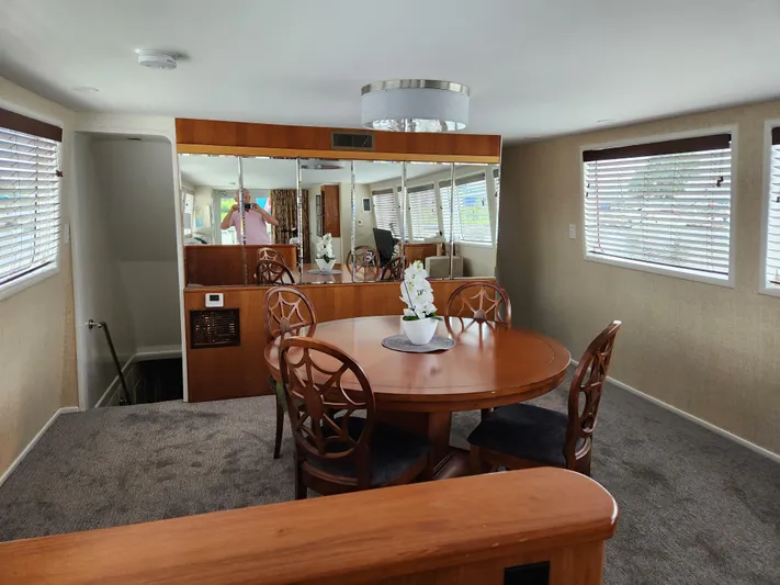 Pier Pressure Yacht Photos Pics Luxurious interior of 1990 Inace 88 Custom yacht with elegant dining area and mirrored walls.