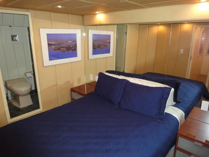 Pier Pressure Yacht Photos Pics Luxurious bedroom in 1990 Inace 88 Custom yacht with blue bedding and ensuite bathroom.