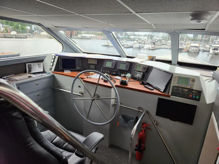 Pier Pressure Yacht Photos Pics Interior of 1990 Inace 88 Custom yacht cockpit with navigation equipment and steering wheel.