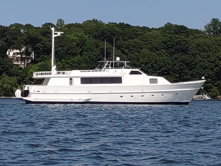 Pier Pressure Yacht Photos Pics White 1990 Inace 88 Custom yacht on calm water with forested background.
