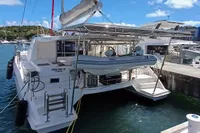 2018 Leopard 48 catamaran docked at marina, featuring solar panels and a dinghy.