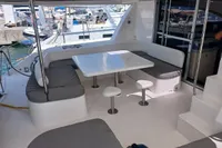 Spacious seating area on a 2018 Leopard 48 yacht, featuring a modern table and cushioned benches.