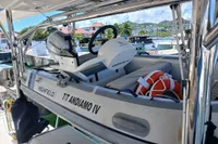 Inflatable boat "TT Andiamo IV" with Honda motor on Leopard 48, docked at marina.