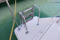 Stainless steel swim ladder on a 2018 Leopard 48 yacht, docked in green water.