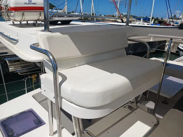 Andiamo IV Yacht Photos Pics White cushioned seating on 2018 Leopard 48 yacht, docked in marina.