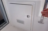 Compartment door on a 2018 Leopard 48 yacht with a handrail and lock.