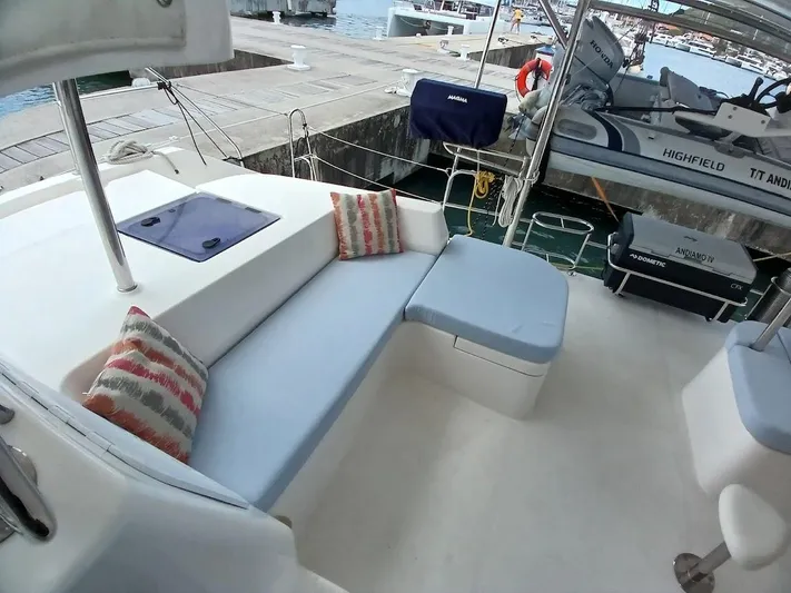 Andiamo IV Yacht Photos Pics Luxurious Leopard 48 yacht deck with comfortable seating, docked at a marina.