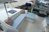 Luxurious Leopard 48 yacht deck with comfortable seating, docked at a marina.