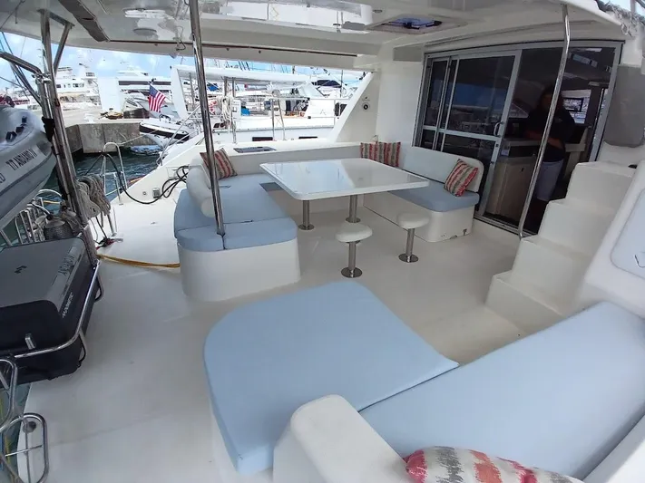 Andiamo IV Yacht Photos Pics Spacious deck of 2018 Leopard 48 yacht with seating and table, docked at marina.