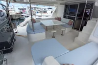 Spacious deck of 2018 Leopard 48 yacht with seating and table, docked at marina.