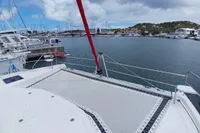Leopard 48 catamaran docked in a marina, showcasing spacious deck and scenic harbor view.
