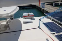 Catamaran deck with solar panels and life raft, Leopard 48, 2018 model, docked at marina.
