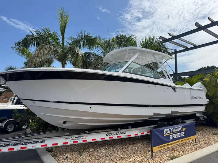  Yacht Photos Pics 2026 Blackfin 302 DC boat displayed on a trailer, surrounded by palm trees.