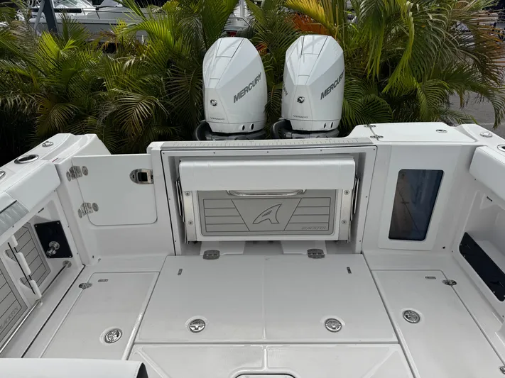  Yacht Photos Pics 2026 Blackfin 302 DC boat deck with dual Mercury engines, surrounded by lush greenery.