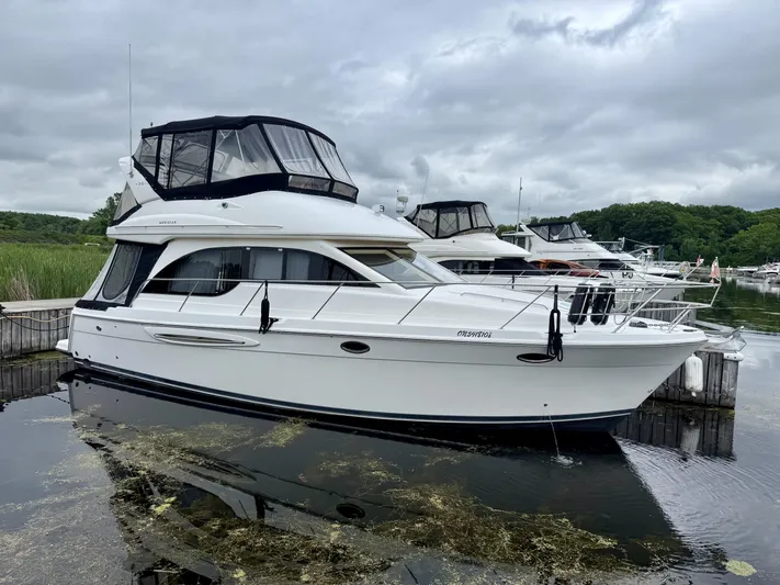  Yacht Photos Pics 2004 Meridian 381 Sedan yacht docked in a marina, overcast sky, lush greenery in background.