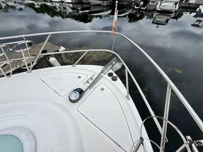  Yacht Photos Pics Bow of 2004 Meridian 381 Sedan yacht docked at marina, featuring anchor and railing.