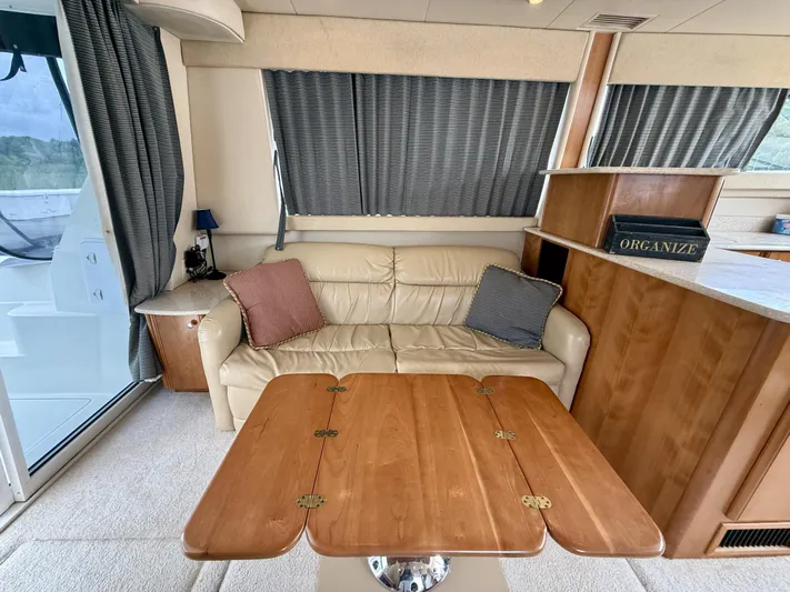  Yacht Photos Pics Interior of 2004 Meridian 381 Sedan with beige sofa, wooden table, and curtains.