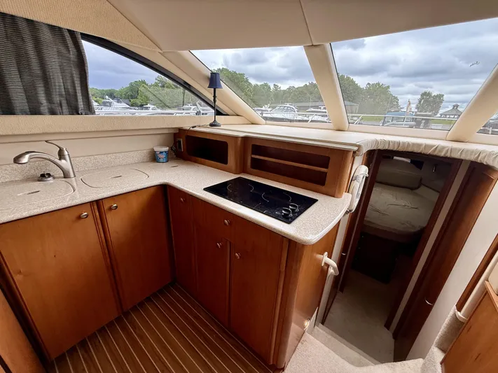  Yacht Photos Pics 2004 Meridian 381 Sedan yacht interior with kitchen, featuring wood cabinets and modern appliances.