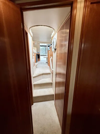  Yacht Photos Pics Interior hallway of a 2004 Meridian 381 Sedan yacht with wooden paneling and carpeted stairs.