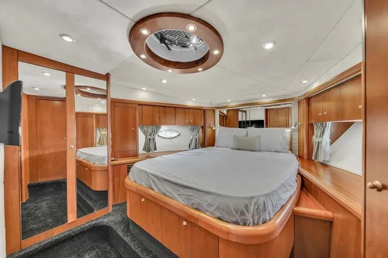  Yacht Photos Pics Luxurious bedroom interior of 2006 Sunseeker Predator 72 yacht with elegant wood finishes.