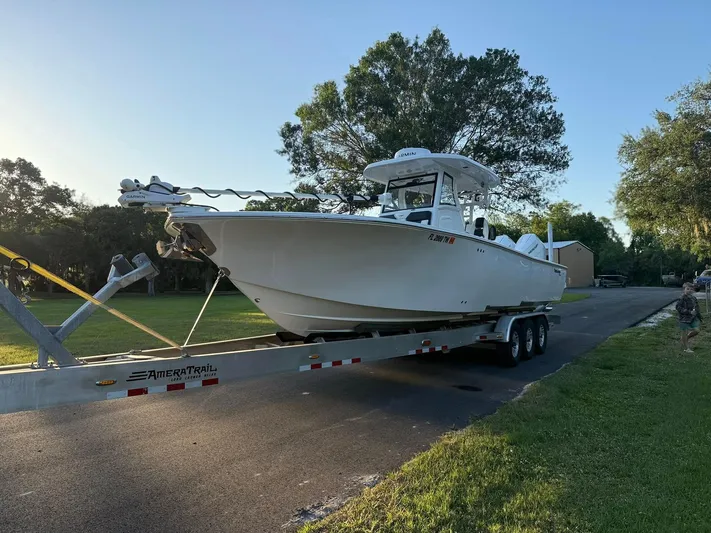  Yacht Photos Pics 2025 Tidewater 3100 Carolina Bay boat on trailer, parked on a sunny street.