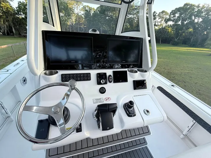  Yacht Photos Pics 2025 Tidewater 3100 Carolina Bay boat dashboard with dual screens and steering wheel.