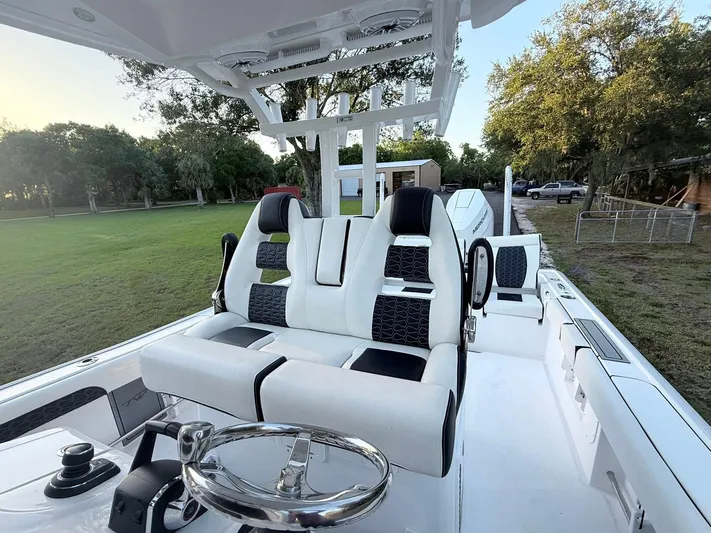  Yacht Photos Pics 2025 Tidewater 3100 Carolina Bay boat interior with modern seating and steering wheel.